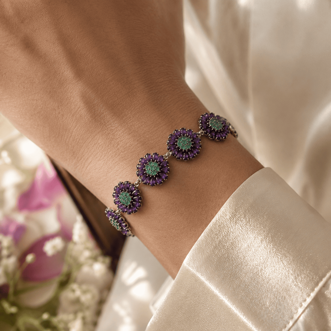 Luxury sterling silver bracelet with African amethyst and Zambian emerald worn on wrist