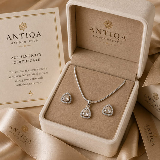 Polki and diamond teardrop necklace and matching earrings arranged inside a luxury jewelry box with Antiqa Handcrafted packaging