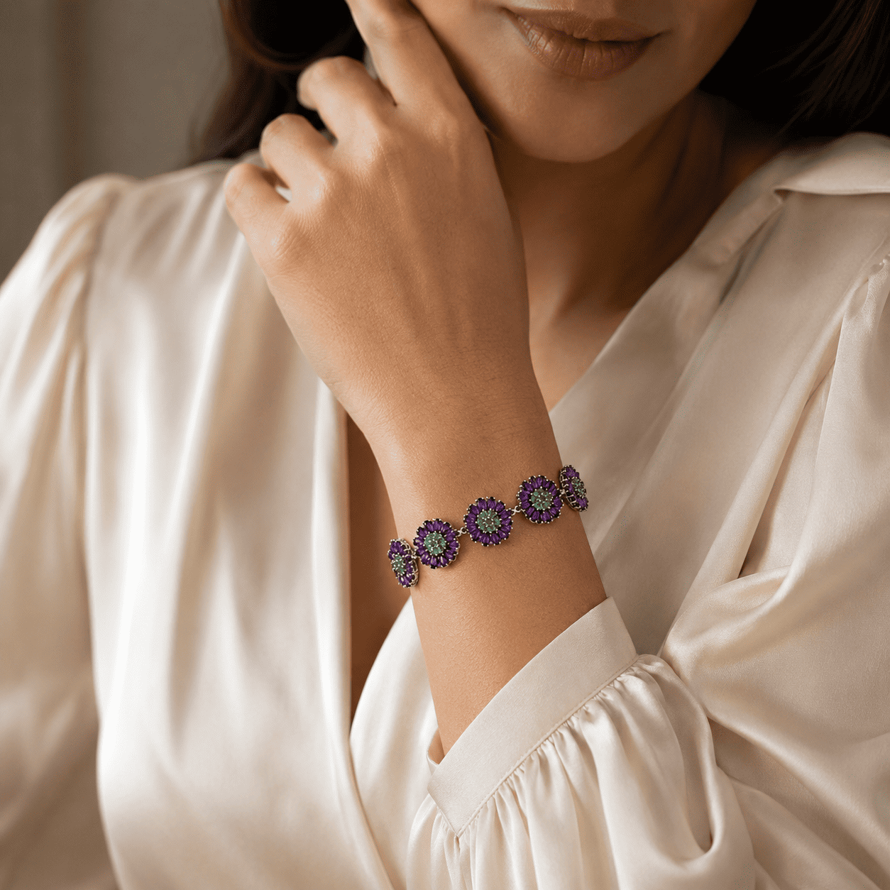 Woman wearing handcrafted sterling silver amethyst and emerald gemstone bracelet