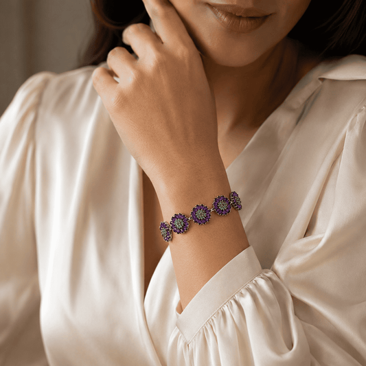 Woman wearing handcrafted sterling silver amethyst and emerald gemstone bracelet
