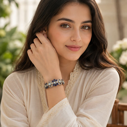 Young woman wearing a handcrafted blue aquamarine and sapphire gemstone bracelet with sterling silver detailing, luxury lifestyle jewelry portrait.