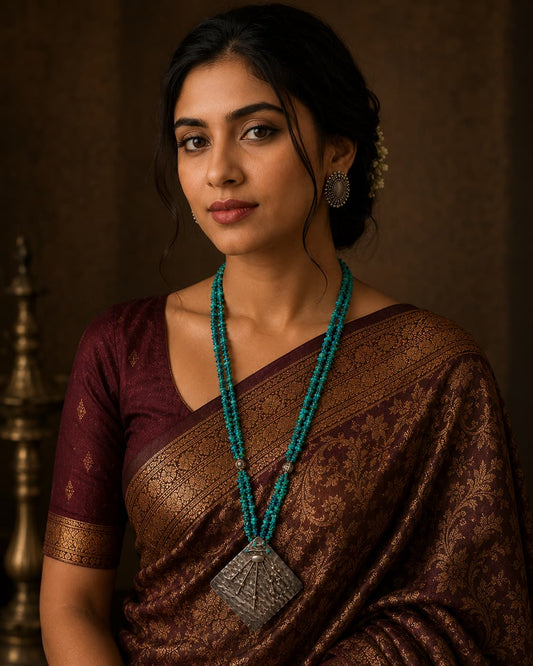 Model wearing Antiqa's handcrafted Persian turquoise beaded necklace with antique silver pendant
