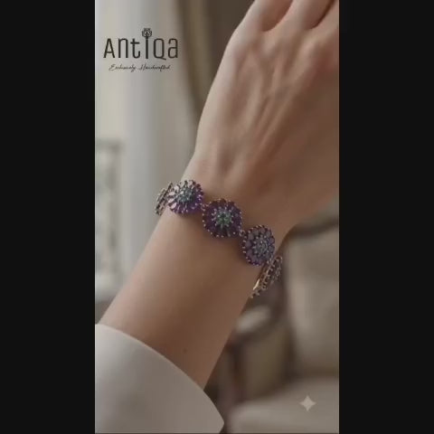 Elegant handcrafted 925 sterling silver bracelet with amethyst and emerald gemstones angled view